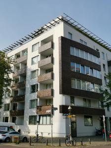 柏林Art'Appart Suiten - kontaktloser Check-In的一座高大的公寓楼,前面有一辆自行车停放