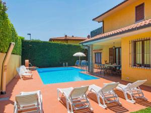 Villa BensiVilla Villa Giada by Interhome的一个带椅子的庭院和一个游泳池