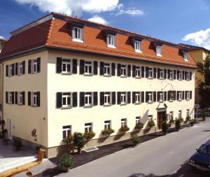 施韦比施哈尔Aspire Kronprinz, Trademark Collection by Wyndham的一座白色的大建筑,有红色的屋顶