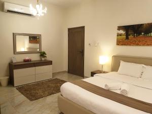 锡卜Muscat Royal Suites的一间卧室配有一张大床和镜子