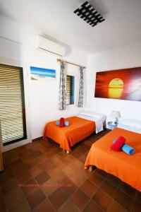 埃斯卡洛卡斯苏拉克公寓酒店的配有橙色床单的客房内的两张床