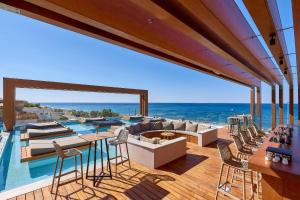 依拉佩特拉Enorme Santanna Beach的一座带游泳池和带椅子的甲板的房子