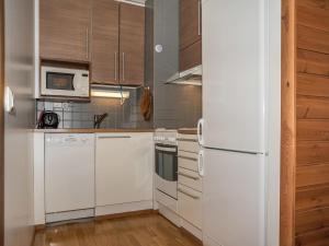 于莱Holiday Home Ylläs chalets a307 by Interhome的厨房配有白色家电和木制橱柜