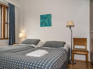 于莱Holiday Home Ylläs chalets a307 by Interhome的一间卧室配有两张床、一盏灯和一把椅子