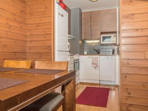 于莱Holiday Home Ylläs chalet a402 by Interhome的厨房配有白色冰箱和木制橱柜。