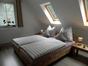 施托尔彭Ferienhaus Buschmuehle - Stolpen的一间卧室设有一张床和两个窗户。