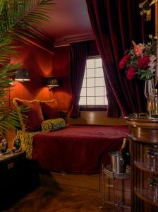 爱丁堡House of Gods Royal Mile的一间卧室设有一张红色墙壁和窗户的床