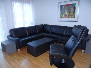 英格堡Apartment Dorfstrasse 7-42 by Interhome的客厅配有黑色真皮沙发和椅子