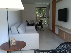 伊塔卡雷Village Angelim的客厅配有白色的沙发和桌子