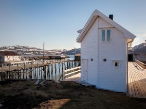 Kongsfjord洛夫森博格布里吉度假屋的水边码头上的白色小建筑
