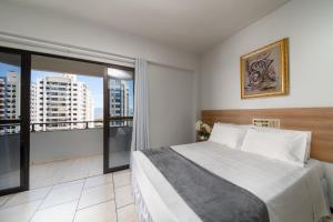 弗洛里亚诺波利斯Lumar Hotel的一间卧室设有一张大床和一个大窗户