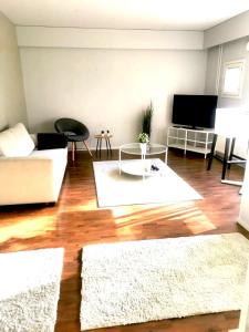 库萨莫Kuusamon Helmi, Sauna, Parveke, Terassi的客厅配有白色沙发和电视