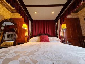 因弗内斯Bluebell House的一间卧室配有一张带红色窗帘的大床