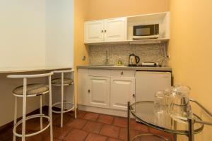 利马El Patio Miraflores的小厨房配有白色橱柜和微波炉
