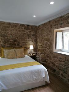 瓜尔达Cantinho D'Aldeia的一间卧室设有一张大床和一个窗户。