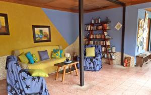 奥罗西Montaña Linda Guest House Orosi的客厅设有黄色沙发和书架