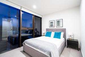 布里斯班Opera Apartments South Brisbane的一间卧室配有一张带蓝色枕头的大床