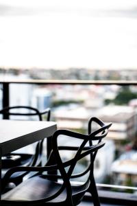 布里斯班Opera Apartments South Brisbane的窗前的两把椅子和一张桌子