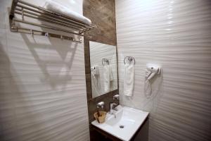 巴耶杜帕尔Hotel Ucla Center的白色的浴室设有水槽和镜子