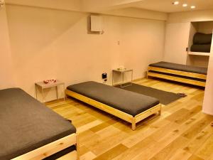 京都Enzo Kyoto Gojo E的一间设有两张床和两张桌子的房间