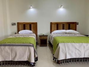 埃斯孔迪多港Lidxi Rosae的两张睡床彼此相邻,位于一个房间里