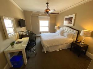 旧金山Kensington Park Hotel的卧室配有白色的床、书桌和椅子