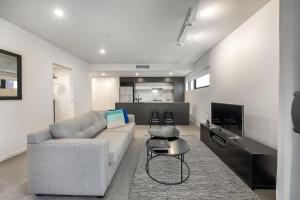 布里斯班Opera Apartments South Brisbane的带沙发和电视的客厅