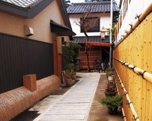 京都町屋京都圣护院酒店的一座种有植物和围栏的房子的庭院