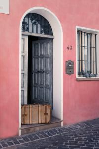 里米尼Cà Tabachera的粉红色建筑中的黑色门,外面有箱子