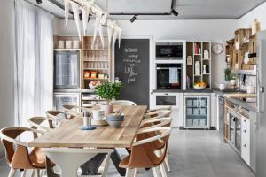 伯尔尼Stay KooooK Bern Wankdorf - Online Check In的厨房配有木桌和椅子