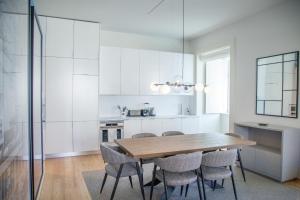 里斯本FLH Augusta's Arch Design Apartment的厨房配有木桌和椅子