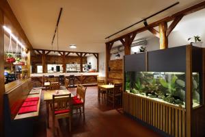 捷克布杰约维采欣洛斯卡克蔓旅馆的餐厅设有鱼缸和桌椅
