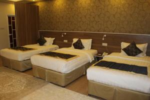 尼兹瓦阿尔迪亚酒店的酒店客房,配有3张带白色床单的床