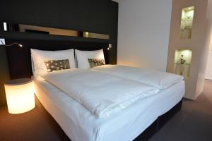 泰格维伦菊克精品酒店的一张大白床,位于带灯的房间