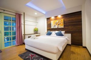 尖竹汶Annowa Resort - Chanthaburi的卧室配有一张白色大床和木制床头板
