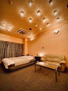 京都嵯峨野酒店（仅限成人）的一间卧室配有一张床、一张沙发和一张桌子