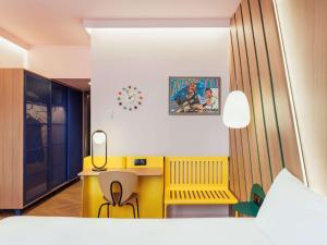 马德里Ibis Styles Madrid City Las Ventas的一间卧室配有黄色的办公桌和黄色的椅子