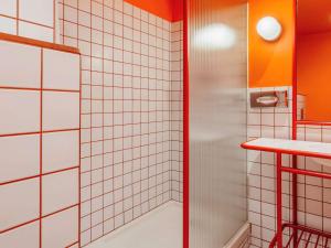 马德里Ibis Styles Madrid City Las Ventas的带淋浴的浴室和白色瓷砖墙壁