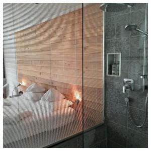圣安东阿尔贝格"Quality Hosts Arlberg" Hotel Lux Alpinae的一间卧室设有一张床和玻璃墙