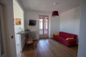 托雷佩利切Appartamento con vista a Torre Pellice的客厅配有红色沙发和电视