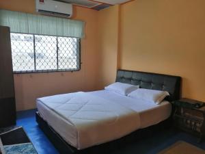 居銮KLUANG BARAT HOMESTAY的卧室内的一张大床,设有窗户