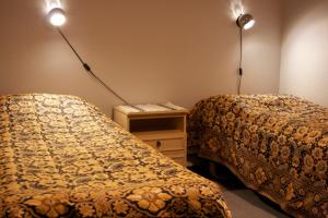 蓬卡哈尤蓬卡哈尔尤酒店的两张床位于带两盏灯的墙上。