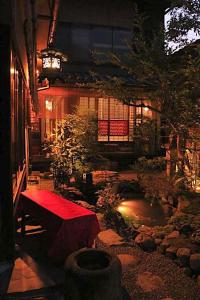 京都祇园紘酒店的一个带红色长凳和池塘的花园