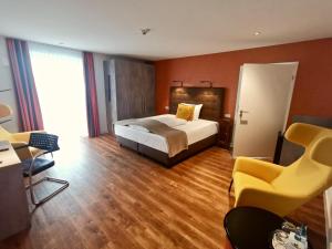 斯图加特H23 Hotel Stuttgart的配有一张床和一把椅子的酒店客房