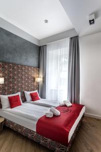 琴斯托霍瓦Apartamenty Nowa Kamienica Częstochowa Centrum Szymanowskiego 22A的一间卧室配有一张带红色枕头的大床