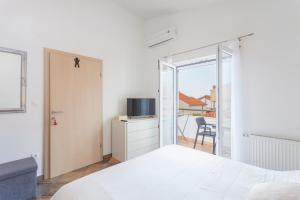 马卡尔斯卡Apartments & Rooms Alagić的一间卧室设有一张床和一个滑动玻璃门