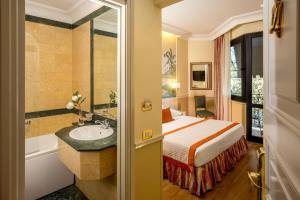 罗马Donna Laura Palace by OMNIA hotels的酒店客房设有床、水槽和浴缸。