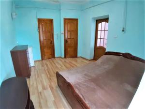 KalushЗатишна квартира в центрі Калуша的一间卧室配有一张床,铺有木地板,拥有蓝色的墙壁