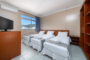 弗洛里亚诺波利斯Rede Andrade Cecomtur的酒店客房设有四张床和平面电视。