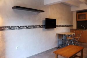 贝尼曼特利La Caseta Benimantell的厨房配有桌子,墙上配有电视